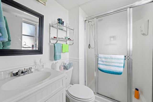 bathroom featuring vanity, toilet, and a shower with shower door