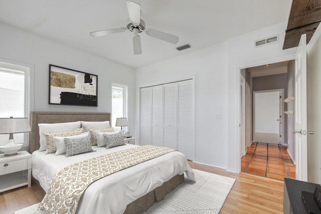 bedroom featuring hardwood / wood-style flooring, ceiling fan, and a closet