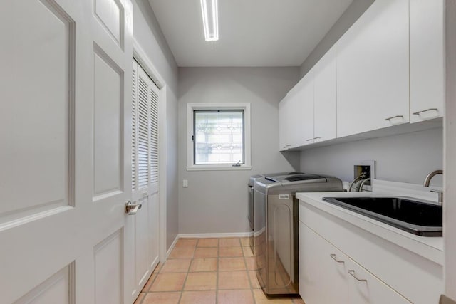 washroom featuring cabinets, light tile patterned floors, washing machine and dryer, and sink