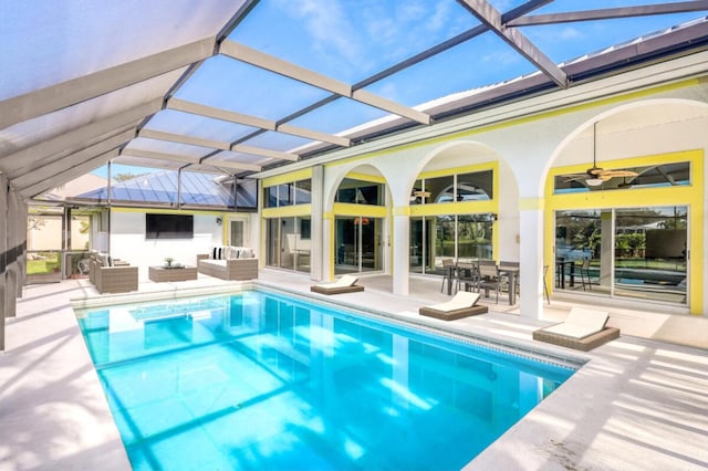 view of swimming pool featuring a lanai, outdoor lounge area, ceiling fan, and a patio area