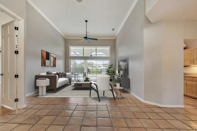 living room with light tile patterned floors, a towering ceiling, ceiling fan, and crown molding