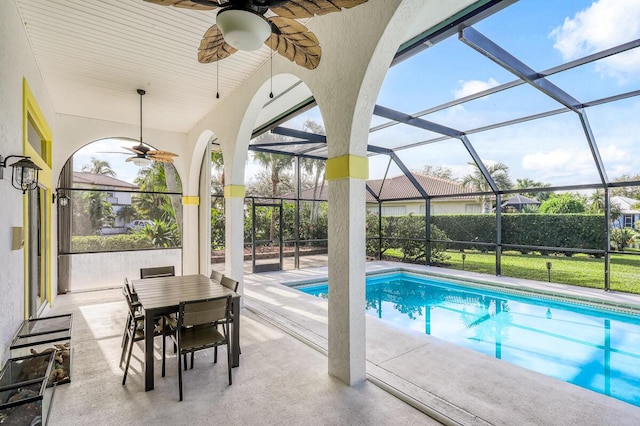 view of swimming pool featuring ceiling fan, a patio area, and a lanai