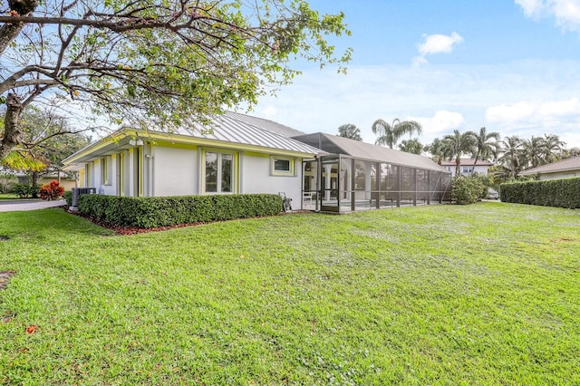 back of house featuring a lanai and a lawn