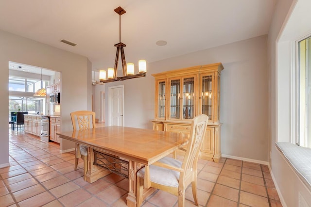 tiled dining area with a chandelier