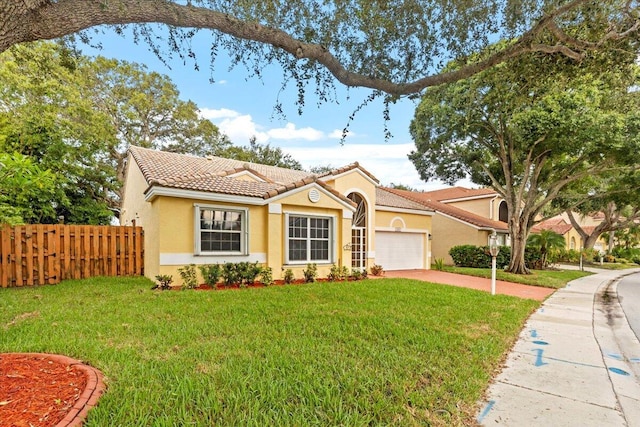 mediterranean / spanish-style home featuring a garage and a front lawn