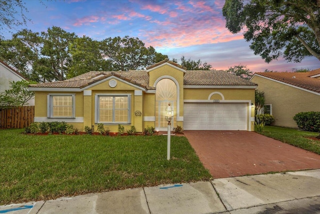 mediterranean / spanish-style house with a yard and a garage