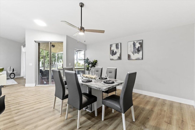 dining area featuring lofted ceiling, ceiling fan, and light wood-type flooring