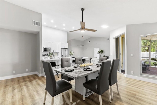 dining area featuring ceiling fan, light hardwood / wood-style floors, and vaulted ceiling