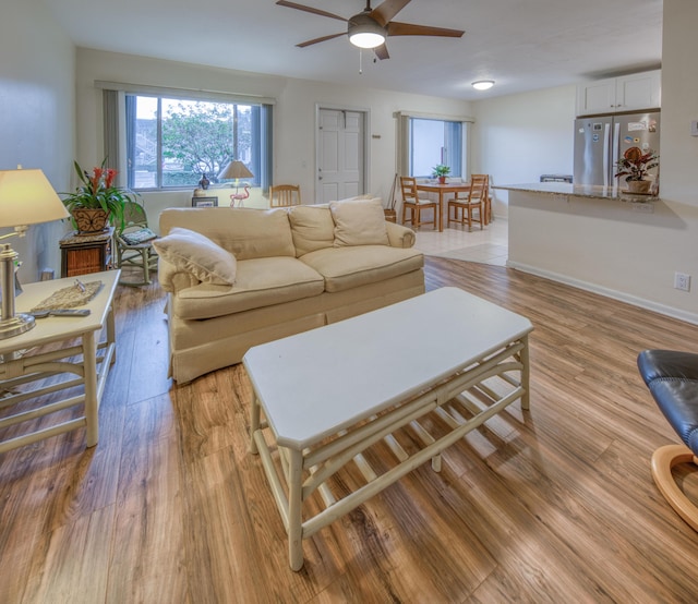 living room featuring ceiling fan and light wood-type flooring