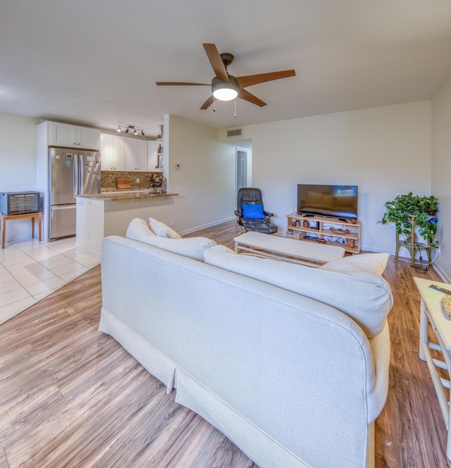 living room with light wood-type flooring and ceiling fan