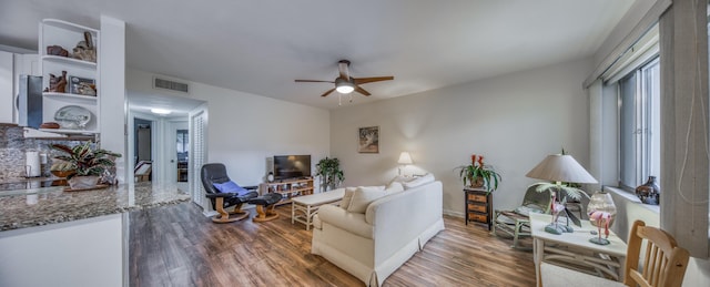 living room featuring ceiling fan and dark hardwood / wood-style flooring