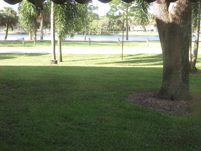 view of property's community featuring a water view, a lawn, and volleyball court