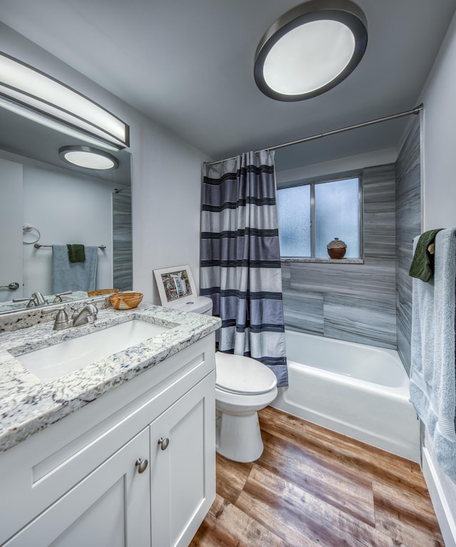 full bathroom with toilet, wood-type flooring, vanity, and shower / tub combo with curtain