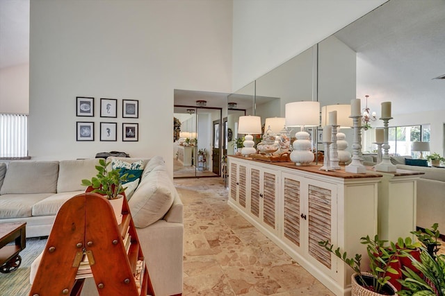 living room with high vaulted ceiling and a notable chandelier