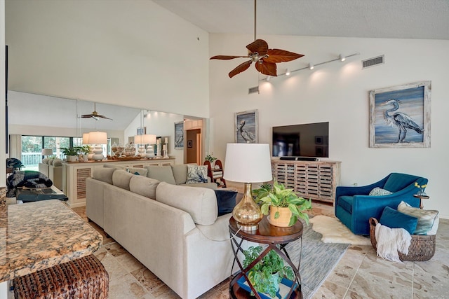 living room with track lighting, ceiling fan, and high vaulted ceiling