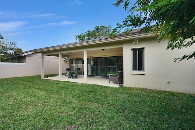 back of house featuring a lawn and a patio