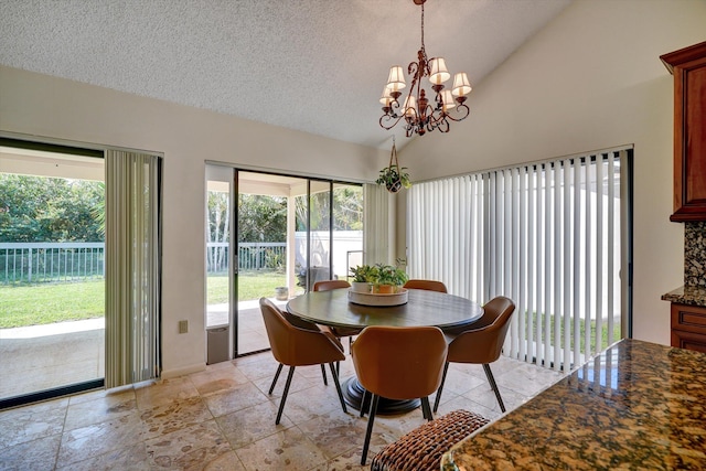 dining area featuring lofted ceiling, a textured ceiling, a notable chandelier, and plenty of natural light