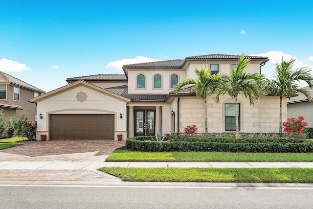 mediterranean / spanish house featuring french doors and a garage