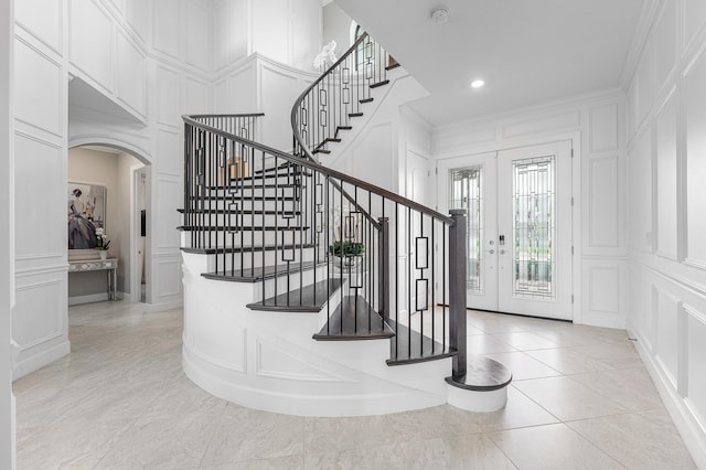 tiled entryway with french doors and ornamental molding