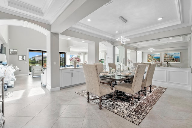 tiled dining area featuring a tray ceiling and crown molding