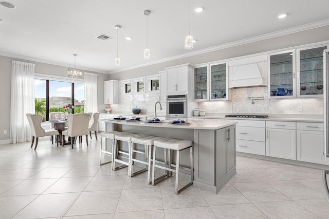 110 Echelon Crest Trl, Jupiter, FL 33478 - kitchen with custom exhaust hood, oven, crown molding, light countertops, and backsplash