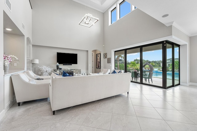 110 Echelon Crest Trl, Jupiter, FL 33478 - living room with ornamental molding, a towering ceiling, arched walkways, and light tile patterned floors