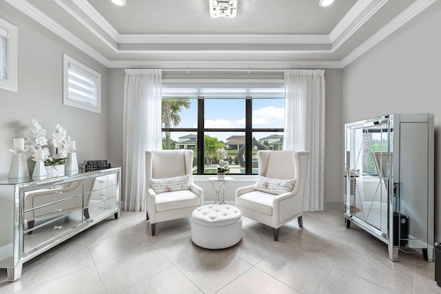 sitting room with a tray ceiling, a wealth of natural light, and crown molding