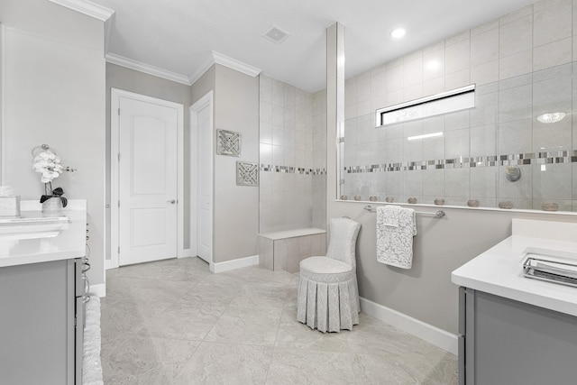 bathroom featuring a tile shower, crown molding, and vanity