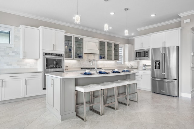 kitchen featuring hanging light fixtures, stainless steel appliances, a kitchen island with sink, and tasteful backsplash