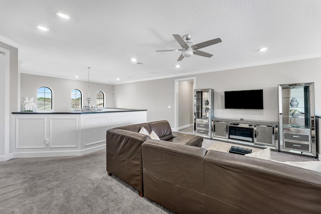 living room with crown molding, ceiling fan, light colored carpet, and a textured ceiling