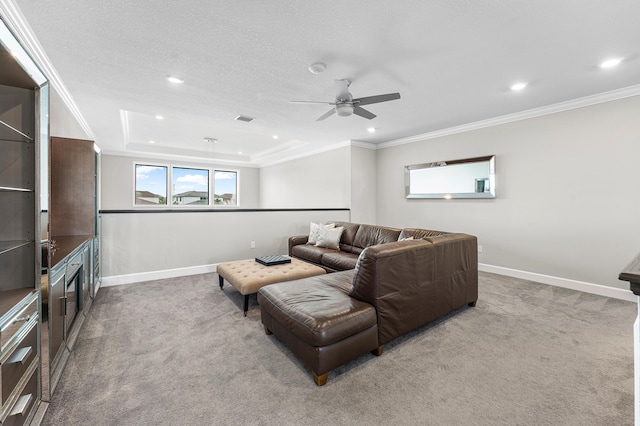 carpeted living room featuring ceiling fan, a textured ceiling, and ornamental molding