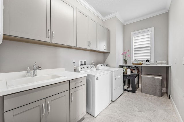 laundry area featuring sink, cabinets, washing machine and dryer, crown molding, and light tile patterned floors