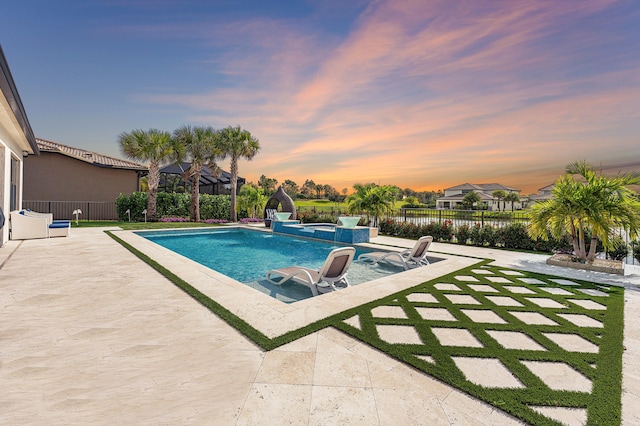 pool at dusk with a patio area