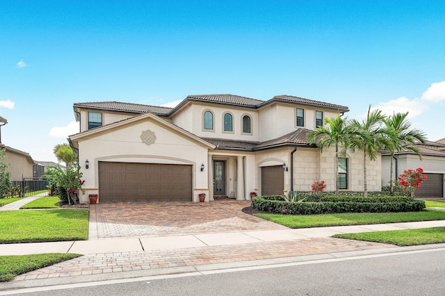 mediterranean / spanish-style home with a front yard and a garage