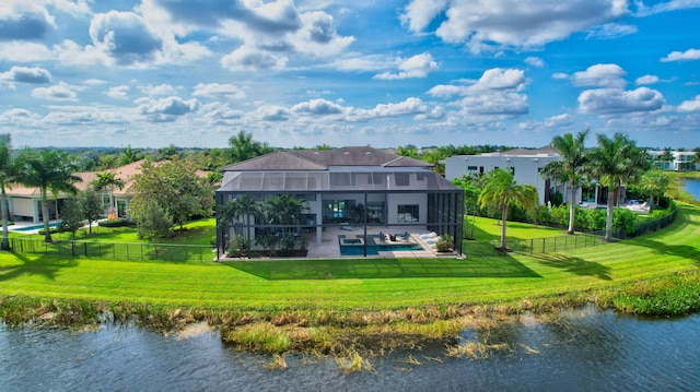 back of house with a yard, a water view, glass enclosure, and a patio area