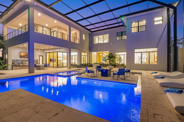 view of swimming pool with a lanai, a patio area, and an in ground hot tub