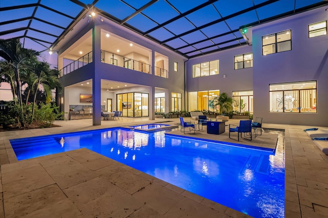 view of pool with a lanai, an in ground hot tub, and a patio