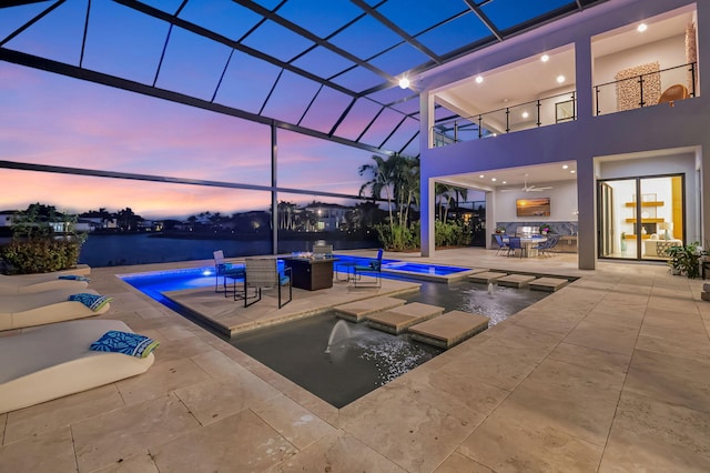 view of swimming pool featuring an in ground hot tub, a lanai, ceiling fan, pool water feature, and a patio area