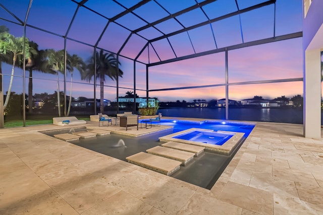 pool at dusk featuring a patio area, glass enclosure, an in ground hot tub, and a water view