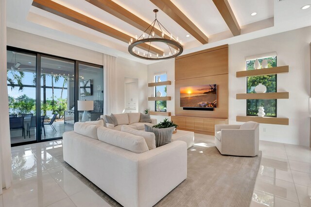 living room with a towering ceiling, beamed ceiling, light tile patterned flooring, and a chandelier