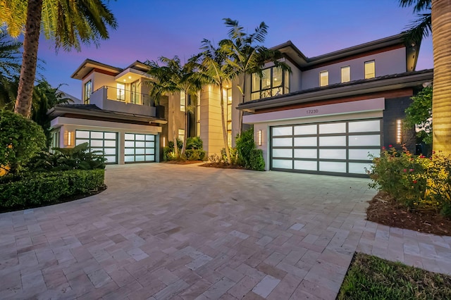 view of front of property featuring a balcony and a garage