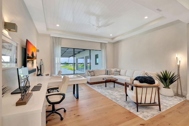 living room with light hardwood / wood-style floors, a raised ceiling, ceiling fan, and wooden ceiling