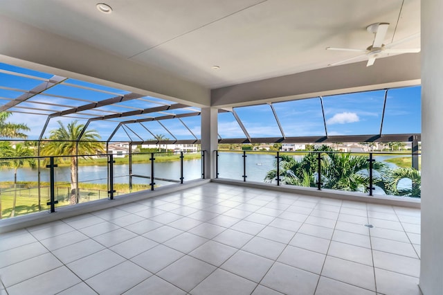 unfurnished sunroom featuring ceiling fan and a water view