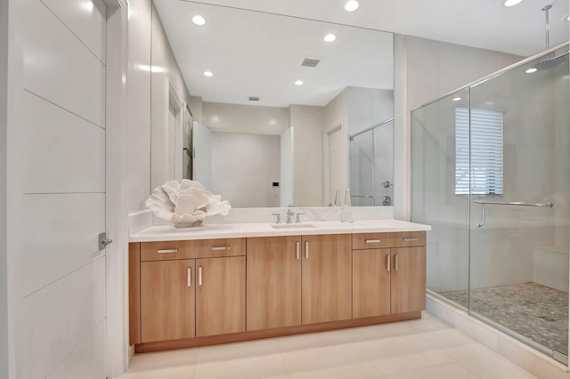 bathroom featuring a shower with shower door and vanity