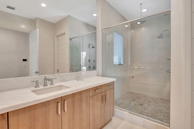 bathroom with an enclosed shower, vanity, and tile patterned floors