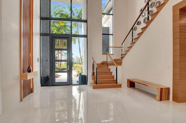 entryway featuring a high ceiling, french doors, tile patterned flooring, and expansive windows