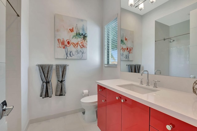 bathroom with toilet, tiled shower, and vanity