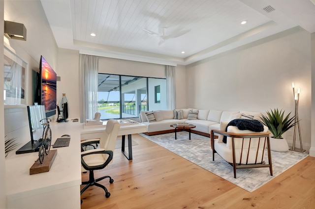 office area featuring a raised ceiling, ceiling fan, light hardwood / wood-style floors, and wooden ceiling