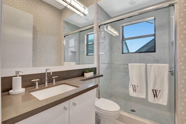 bathroom with toilet, a shower with door, and vanity