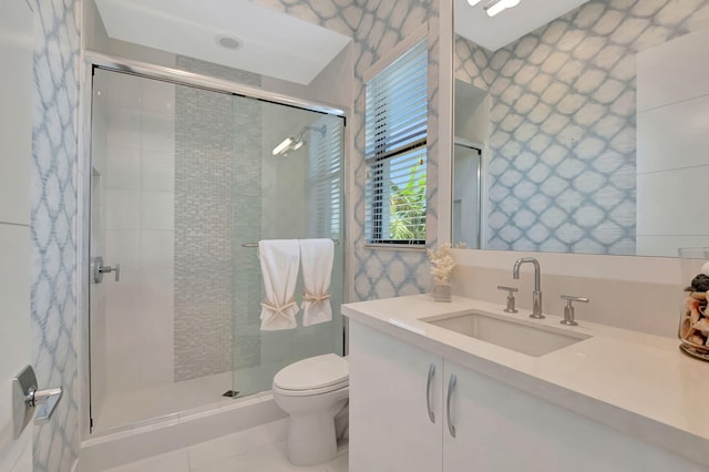 bathroom featuring toilet, tile patterned floors, a shower with shower door, and vanity